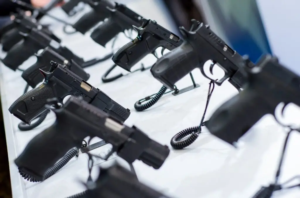 Black handguns are displayed for sale.